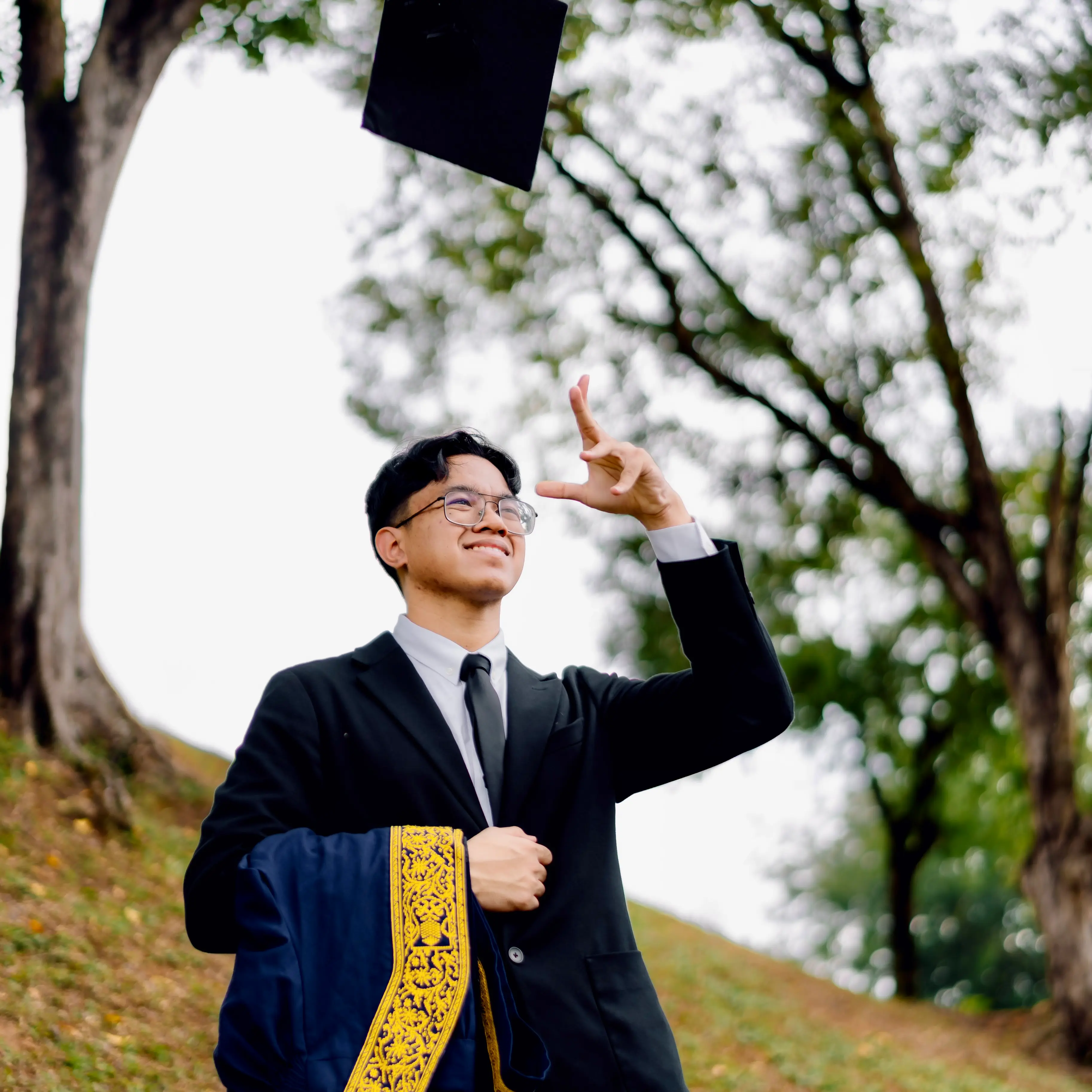 Danish Suffian smiling outdoors in graduation attire